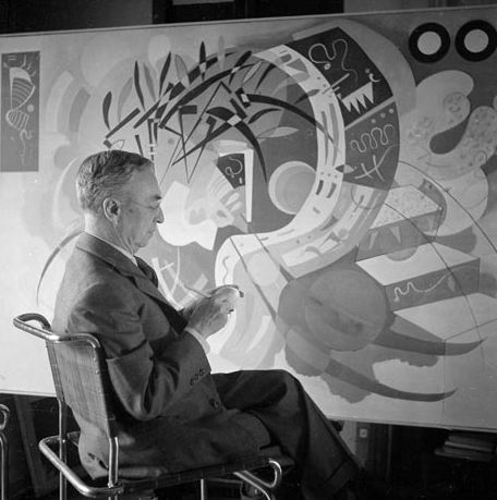 Image of Wassily Kandinsky seated before one of his paintings