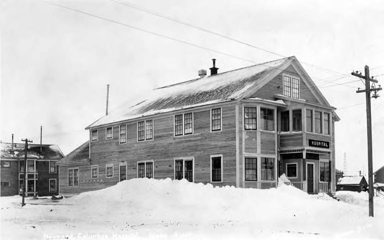 Large wooden house-like building with snow and power lines