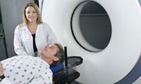 A photograph of a doctor helping a patient receive an MRI. Link to the Doctors, Patients, and Diseases section.