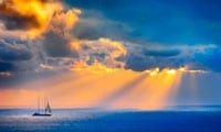 Rays of sunlight seen over a blue ocean. Link to the Poetry section.