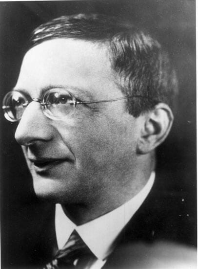 Photo of Alfred Doblin, a man in glasses with a slight smile facing the viewer's left and looking up