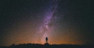 Photograph by Snapwire on Pexels. A silhouette is visible against a purple and orange sky filled with stars.