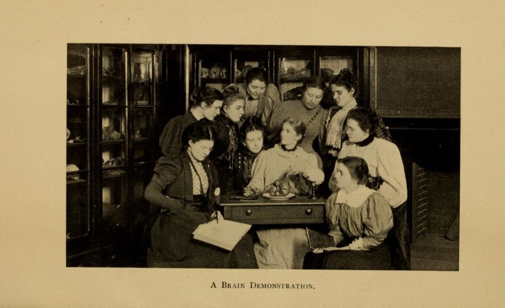Photograph of a class of future female doctors observing a brain dissection.