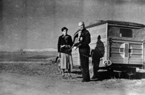 Dr. Norman Bethune and an unnamed woman stand in front of a mobile blood unit