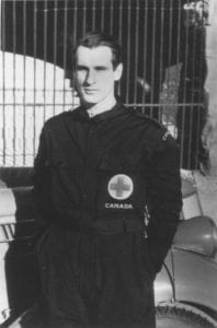 Hazen Sise, a man with pale skin and dark hair, wears a Red Cross Canada uniform.