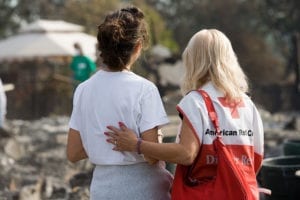 Red Cross volunteer offers support to a victim of a climate change related disaster