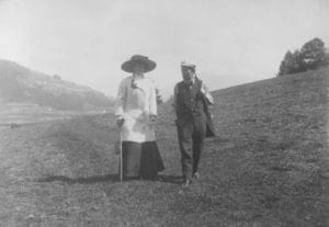 Mahler and his wife walking in a field.