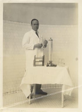 Black and white photograph of Charles Richard Drew holding lab instruments