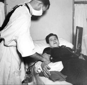 A patient donating blood in the early days of blood banks