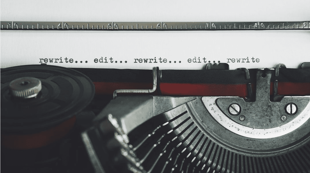 Typewriter displaying the text "rewrite... edit" suggesting the writing process