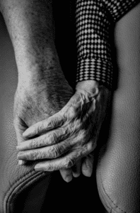 The caring hands of a caregiver in hospice