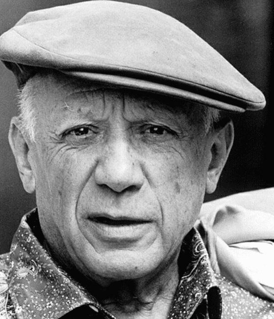 Pablo Picasso, a man with white hair and flat hat in patterned shirt looking at camera. For whom Pablo Picasso syndrome is named.